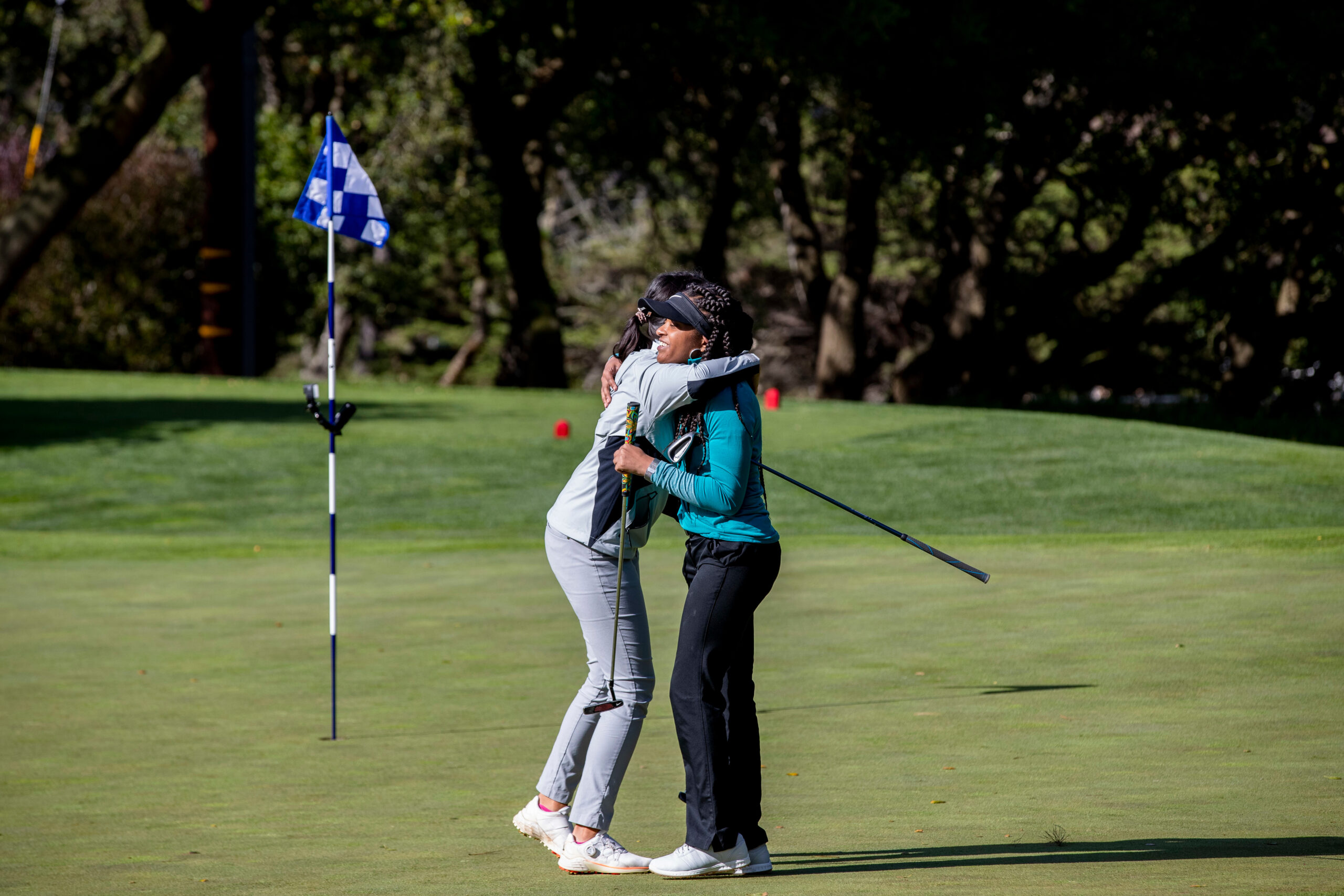 Participants hugging on a putting green.