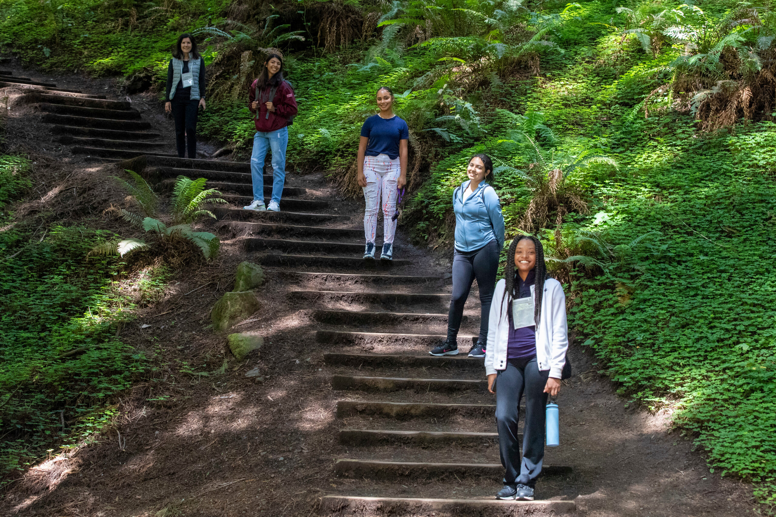 Group of participants posing on steps in a forest.