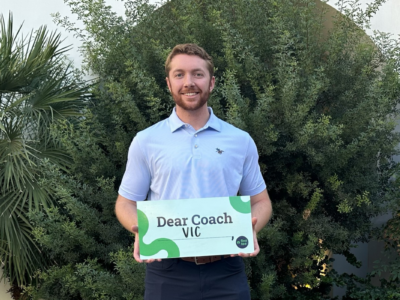 Alumni holding Dear Coach sign