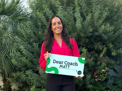 Alumni holding Dear Coach sign